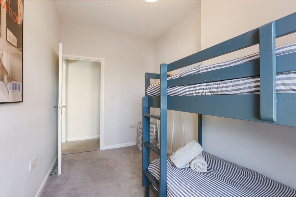 Spacious guest room with open hanging space, full-length mirror and desk