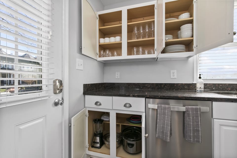 Kitchen cabinets brim with an abundance of cups, dishes, and bowls.