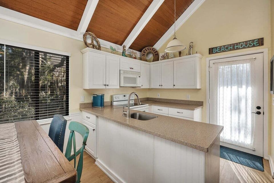 Kitchen with white cabinets, granite counters, and island