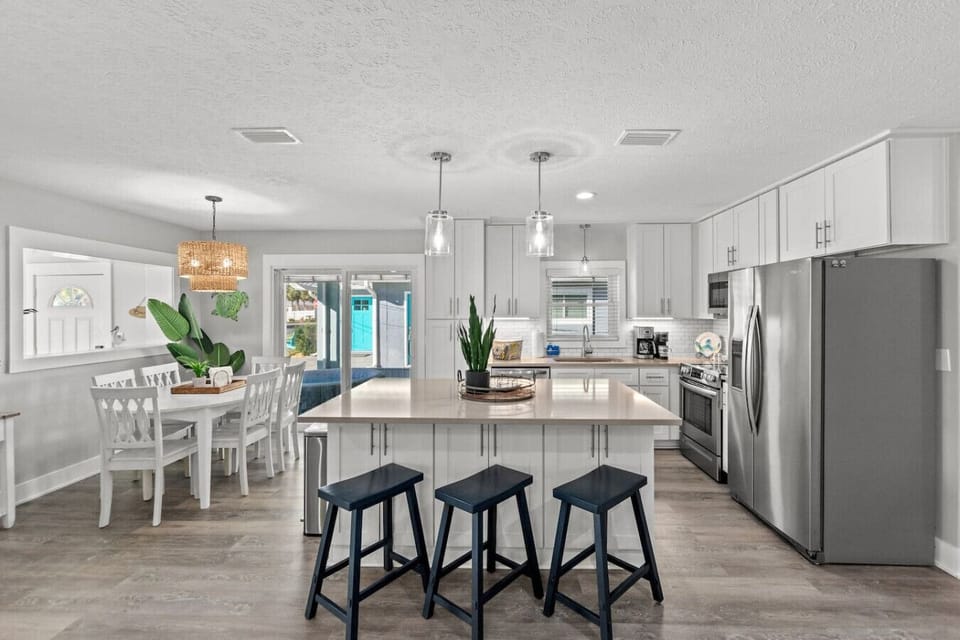 Step into a bright, airy kitchen featuring sleek stainless steel appliances, a cozy dining table, and windows framing beautiful outdoor views—perfect for cooking, dining, and enjoying the scenery.