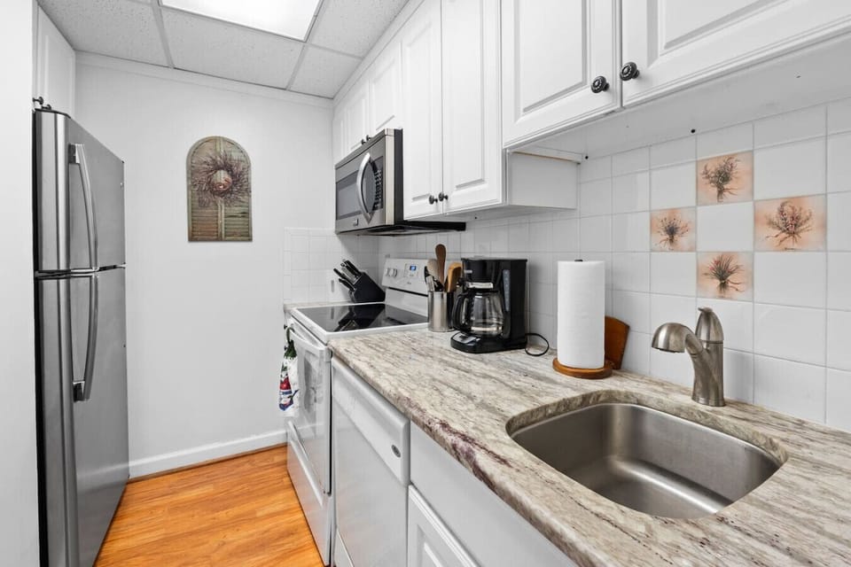 The kitchen includes appliances, cookware, silverware, cutlery and a coffeemaker.