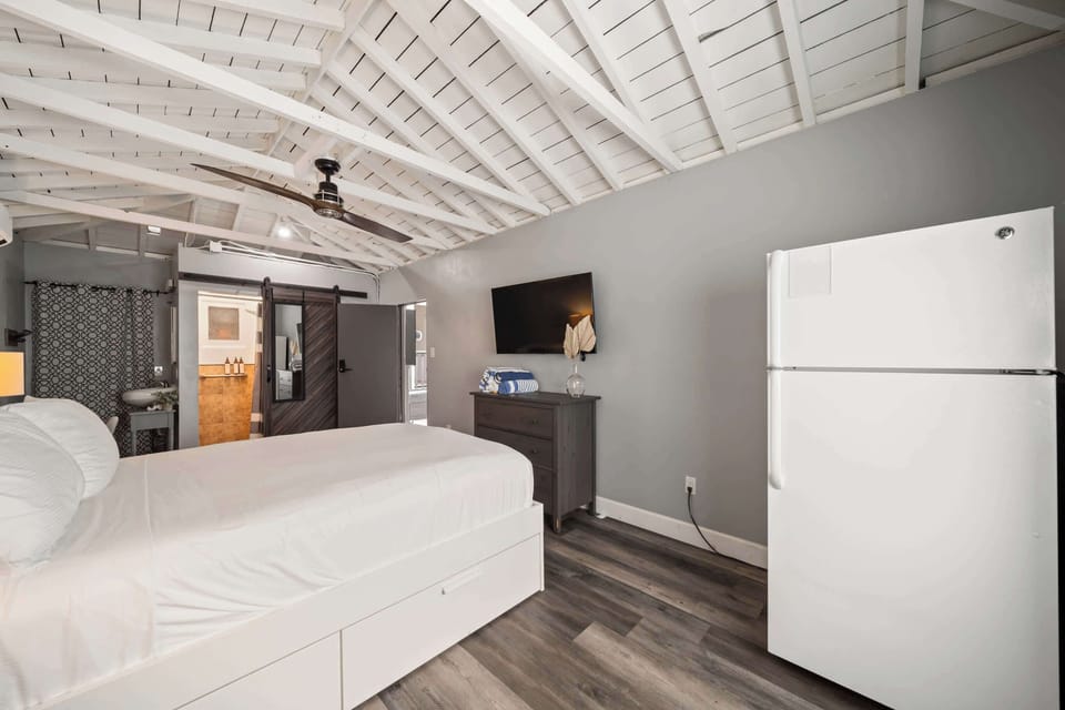 Bedroom 3 with queen bed, TV, workspace, refrigerator, ensuite, and private entrance