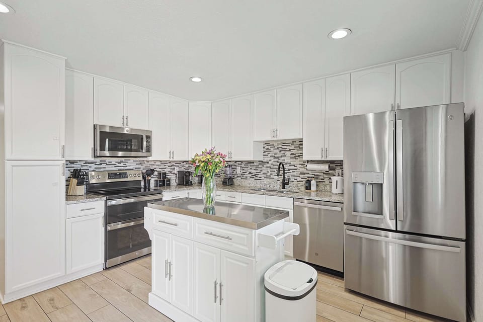 Well-lit kitchen, featuring a large refrigerator and all the essentials for your cooking needs