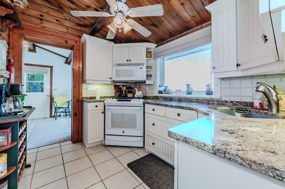 This bright, functional kitchen offers ample space, charming wood accents, and easy access to the deck. Cook meals with views of Georgian Bay and gather for memorable family dinners.