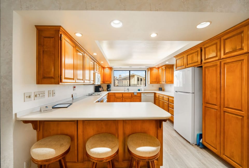 Kitchen is equipped with cooking basics and appliances plus a bar seating for three