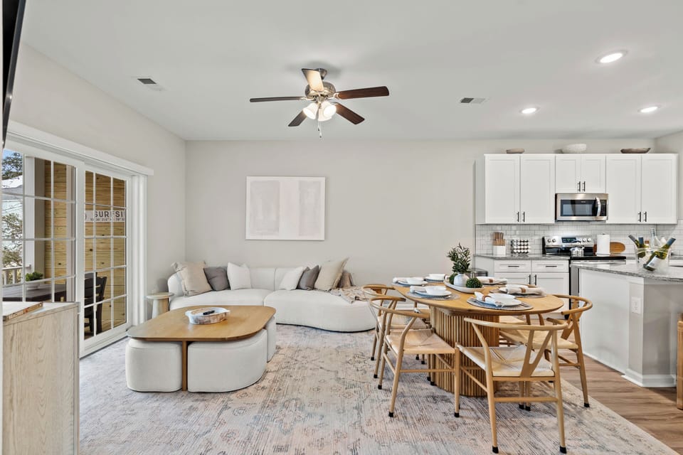 The living room has an open design that flows into the dining room and kitchen