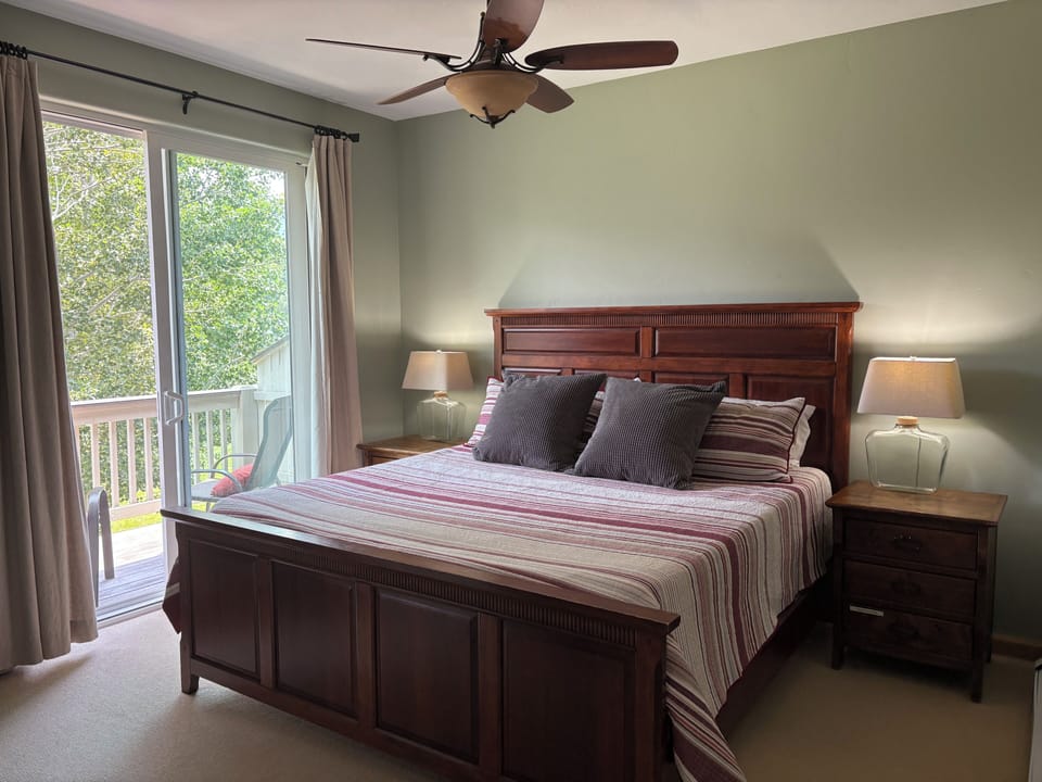 King bed in primary suite with deck overlooking golf course