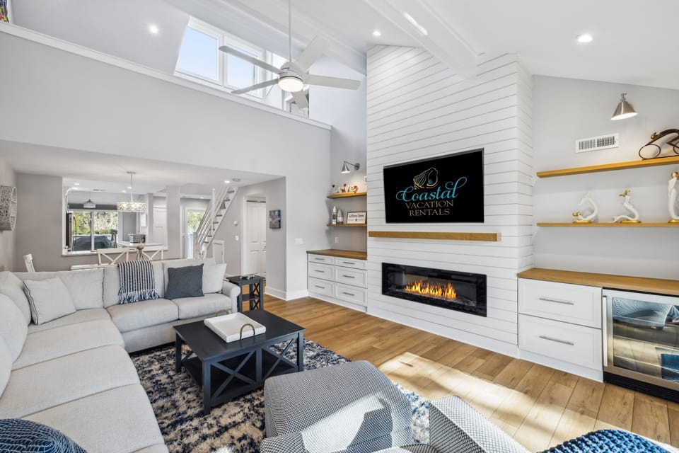 Living room with a large sectional and tv with views of the private patio.