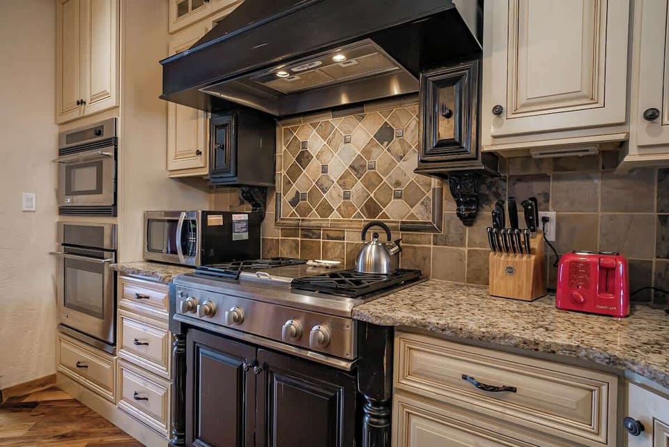 Cook like a pro with this chef-inspired setup featuring a premium gas stove, designer range hood, granite countertops, and built-in double ovens. Everything you need for a cozy night in or an impressive group meal.