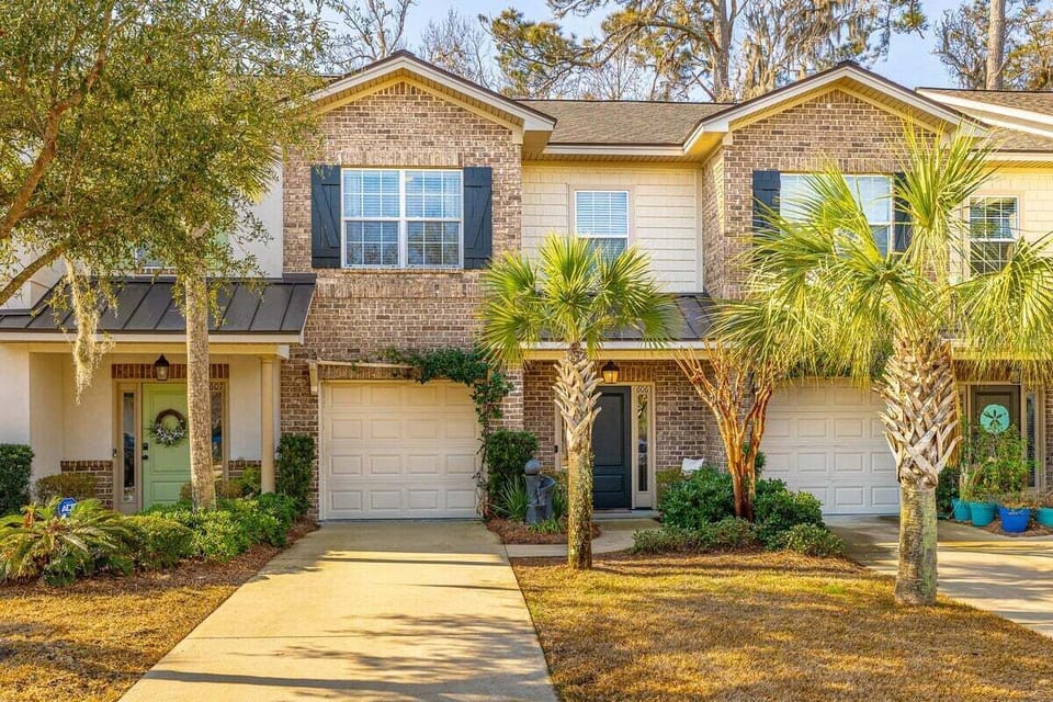 Brick exterior property with garage and palm trees