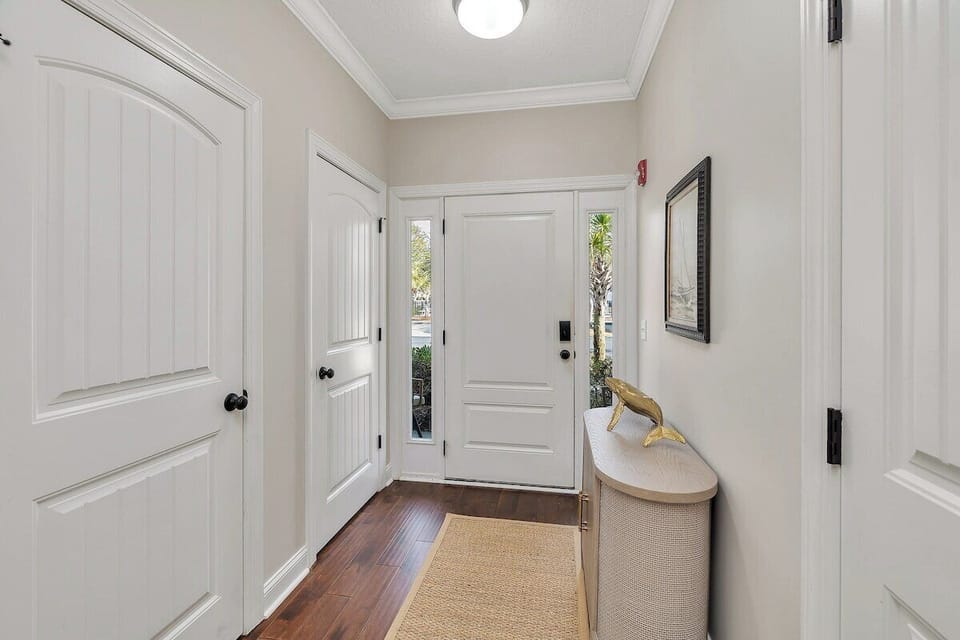 Bright entryway with hardwood floors and white paneled door