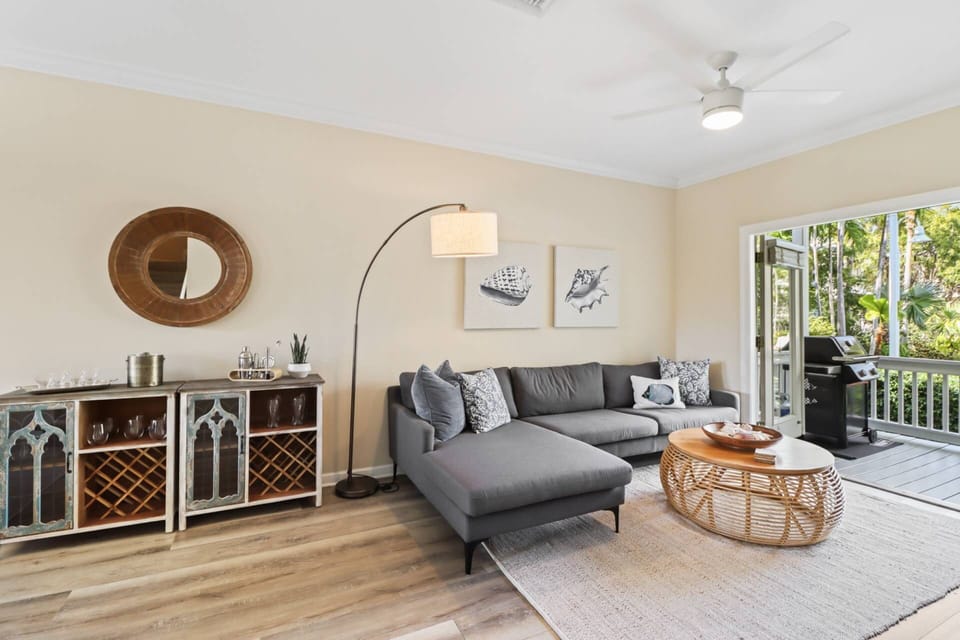 The living room features comfortable seating, perfect for lounging after a day of island adventures or gathering for a cozy movie night.