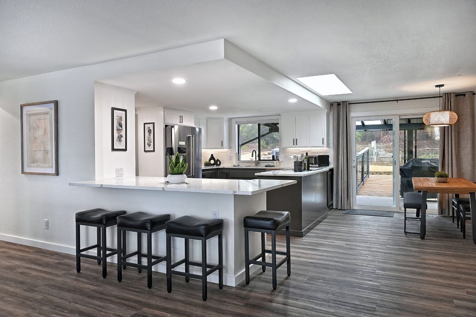 Modern open kitchen and dining area with sleek finishes, ample seating, and access to the outdoor patio for a seamless dining experience