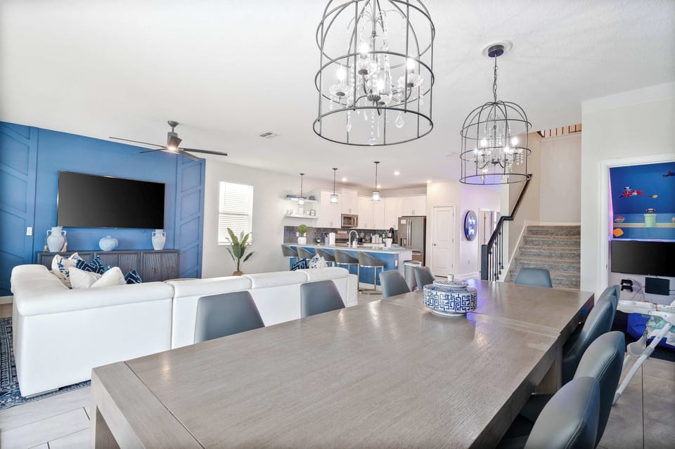 Open floor plan connects the downstairs living room, dining room and kitchen. Huge leather sectional couch, 10+ table, and barstools provide room for the whole family to spend time and dine together! Hideaway play space with PlayStation in stairwell