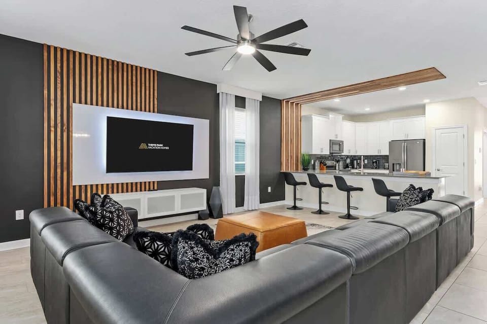 Downstairs living room with giant sectional couch. The spacious open floor plan connects the kitchen, living room and dining room