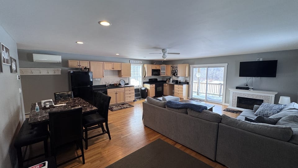 Living room with sizeable L-shaped couch with open concept to kitchen and dining area