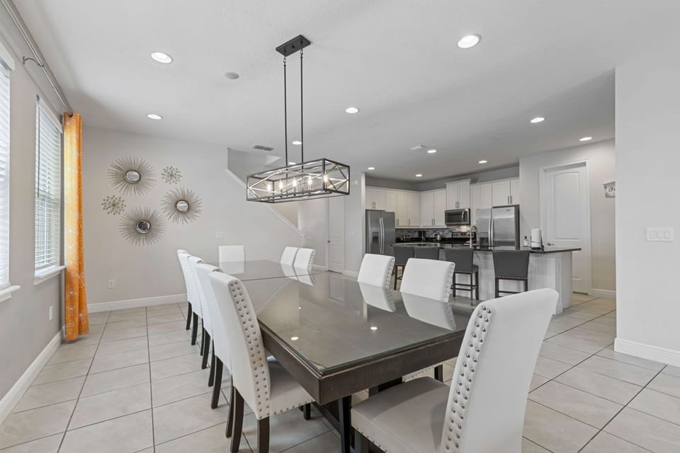 Elegant dining area with seating for ten, adjacent to a modern kitchen.