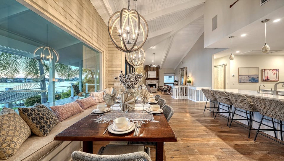 The dining table takes center stage—perfect for sharing meals, laughter, and sunset views through the wide open living space beyond.