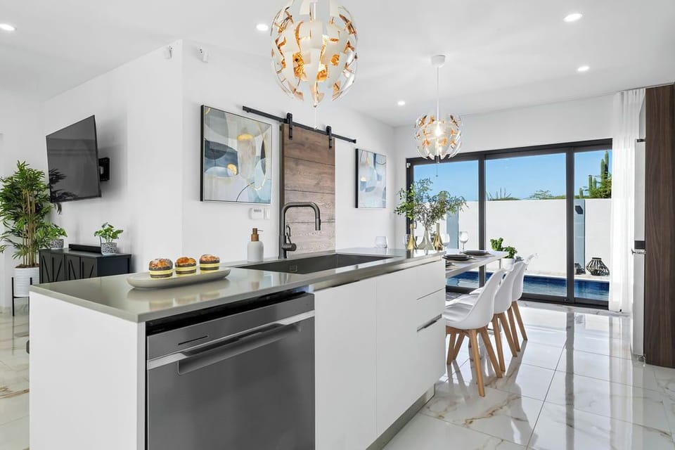 A truly spectacular, modern kitchen designed for both gourmet cooking and lively gatherings! Large glass doors invite the sunshine in and lead directly to your private outdoor space, making alfresco dining a breeze!
