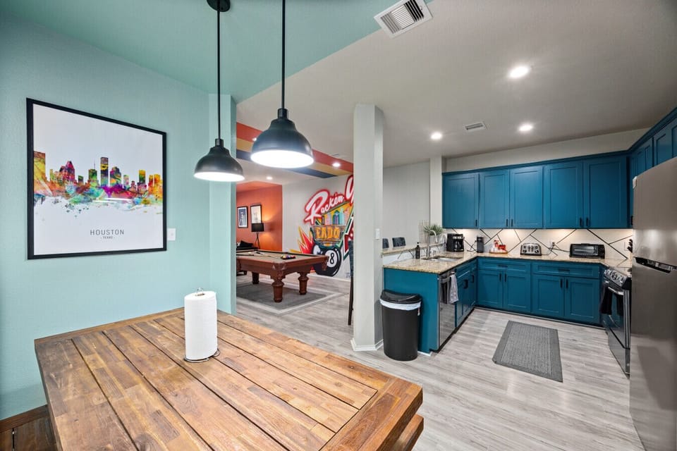 Open-concept layout featuring dining table, pool table, and fully stocked kitchen—ideal for groups to gather, cook, and unwind together.