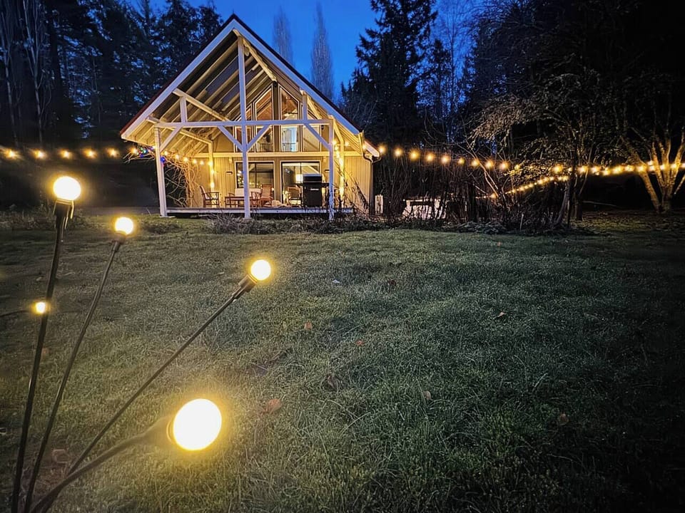 The house at dusk with solar and LED string lighting creates a charming and beautiful atmosphere on the spacious property