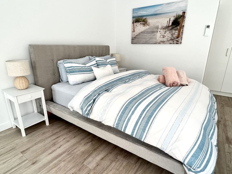 Bright coastal-style bedroom with a plush bed and fresh, airy feel