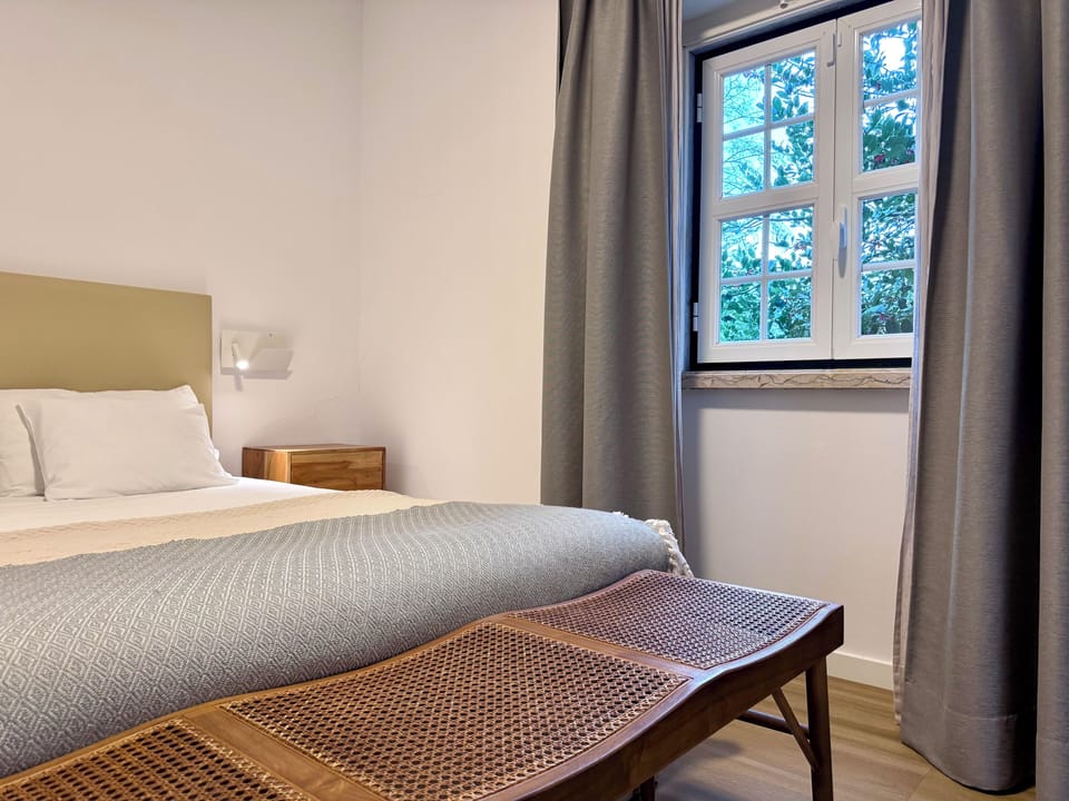 Queen size bed with soft cotton linens and blackout curtains