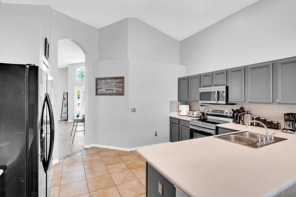 Fully equipped kitchen at Seasons vacation rental near Disney, with stainless steel appliances and modern design.