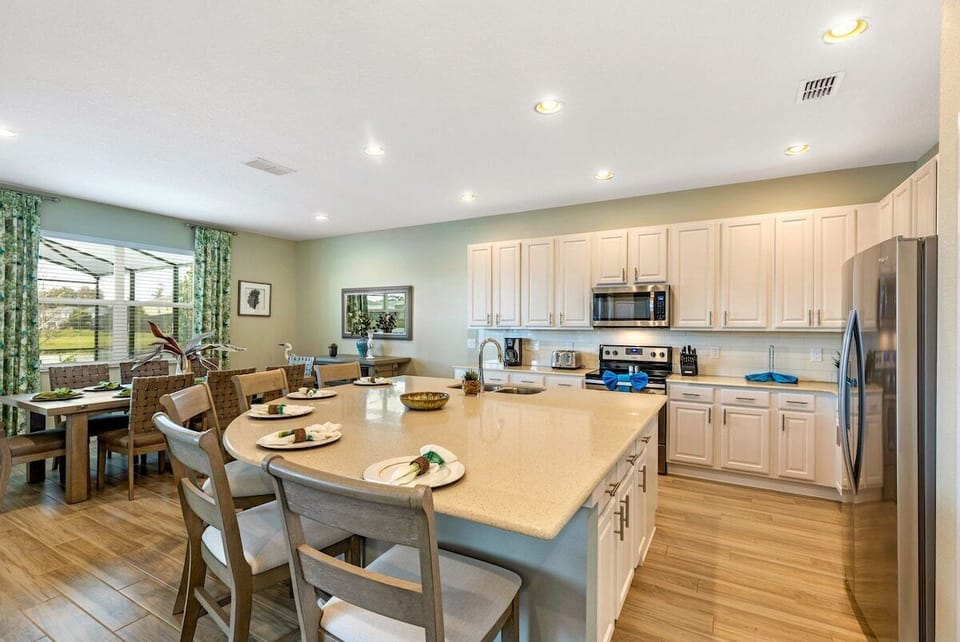 Step into a stunning and expansive kitchen, thoughtfully designed with an open-plan layout and a central island that combines elegance, practicality, and style