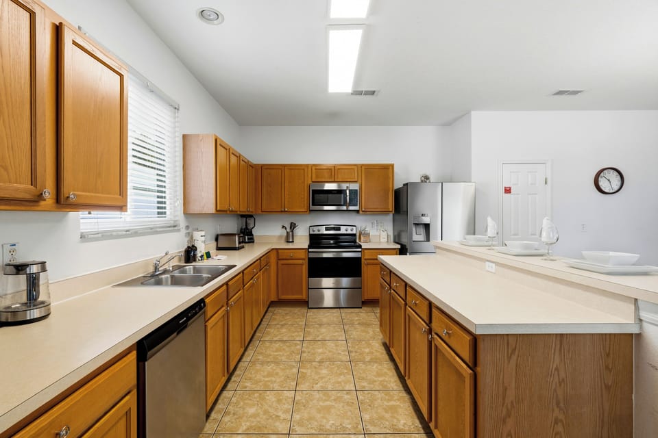 Fully equipped open-concept kitchen with modern appliances and bar seating.
