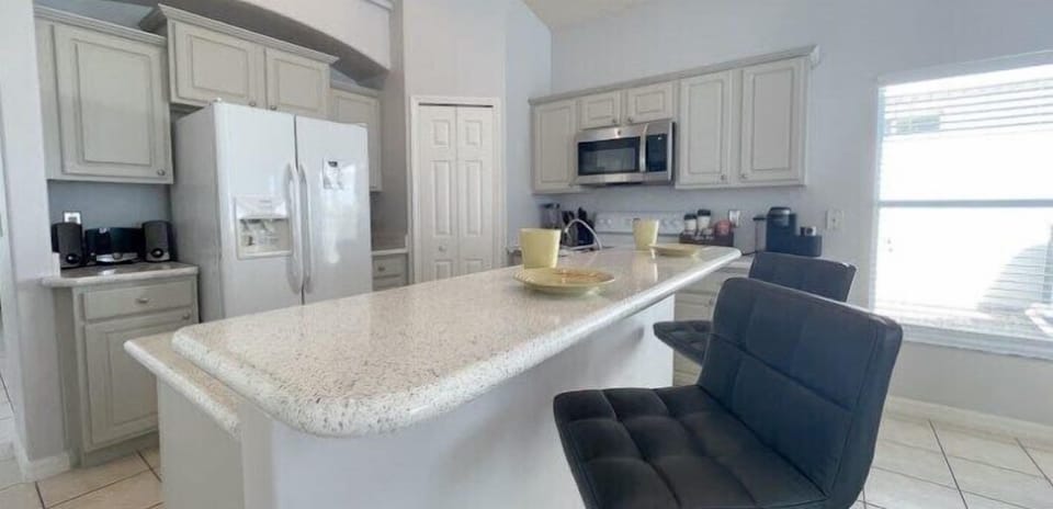 The kitchen island with bar seating offers a perfect spot for casual dining or chatting while preparing meals. The bar stools are comfortable and stylish.