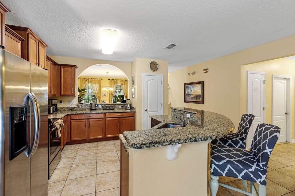 The gourmet kitchen features a collection of high-end stainless steel appliances, including a professional-grade range, oven, and a side-by-side refrigerator.