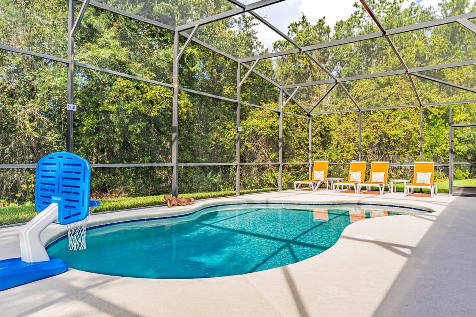 Enjoy your own screened-in pool surrounded by peaceful greenery — perfect for relaxing or family fun under the Florida sun.