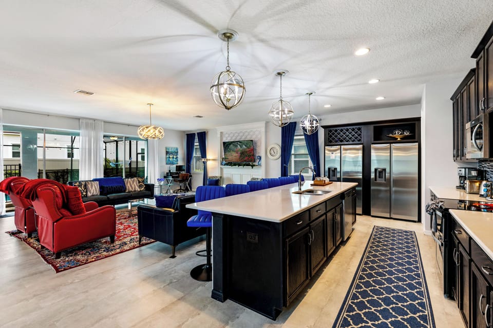 This stylish kitchen features dark cabinetry, a spacious island, and seating for six—perfect for casual breakfasts, evening cocktails, or serving up a buffet for the whole crew.