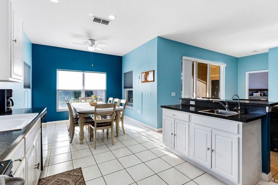 The inviting and well-lit kitchen is designed to be the heart of the home, offering a delightful view of the pool.