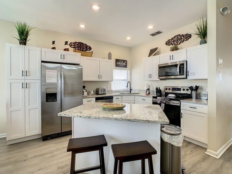 The spacious kitchen island with bar seating makes for an ideal gathering spot for breakfast or evening snacks. This Orlando home near Disney combines functionality with modern flair—perfect for entertaining friends or family.