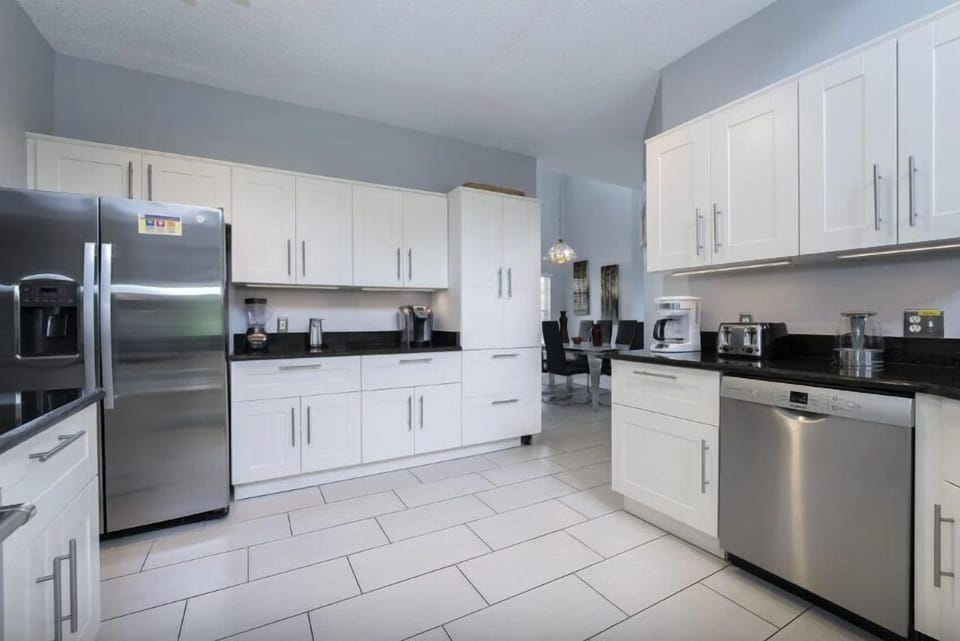 A large modern kitchen with stainless steel appliances is both sleek and functional, combining contemporary design with top-of-the-line materials.