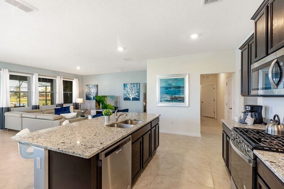 Open plan kitchen with modern appliances, large island and breakfast bar seating for 4
