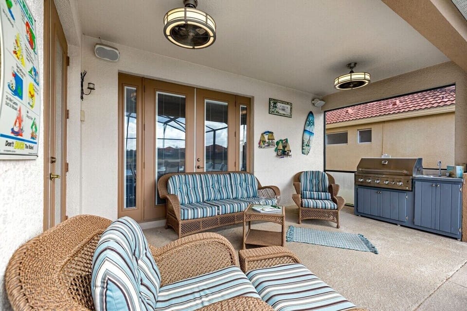 The seating area features comfortable outdoor furniture, including plush sofas and armchairs with weather-resistant cushions.