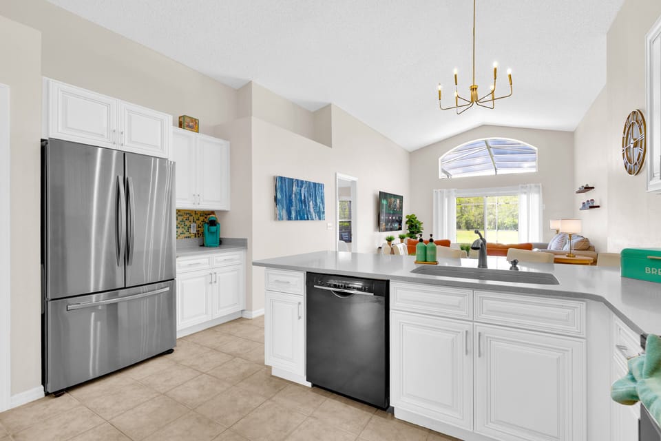 Prep meals with ease in this Florida villa kitchen featuring stainless appliances and just a short drive to Disney.