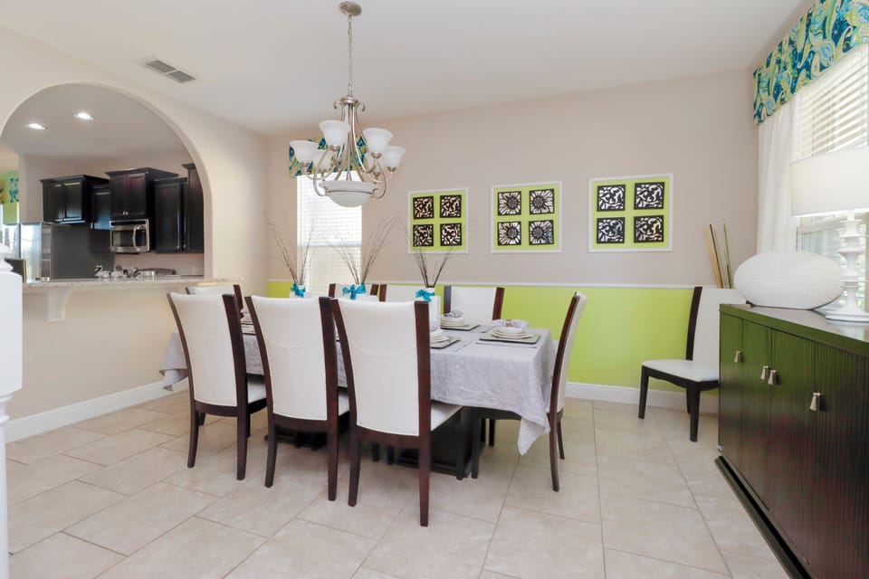 The formal dining area offers seating for eight and is thoughtfully styled for both everyday meals and special gatherings. Located just off the kitchen in Solterra Resort, this space adds a touch of elegance and functionality to your Florida home base near Disney.