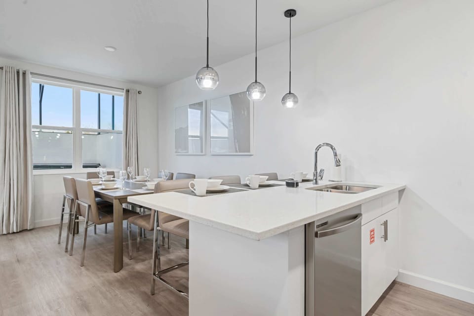 Modern kitchen and dining space, perfect for savouring meals - Sleek countertops, pendant lighting, and a fully stocked kitchen make every meal a breeze - Enjoy seamless flow from the kitchen to the dining area, ideal for entertaining and bonding