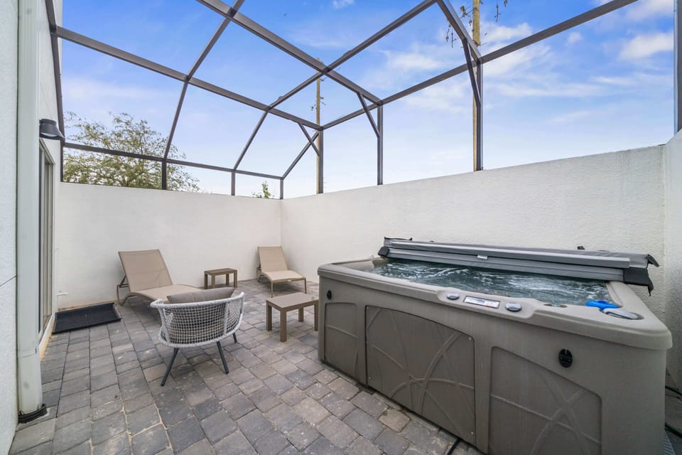 Relax in the private screened-in patio featuring a bubbling hot tub for ultimate comfort - Unwind on cozy loungers under the open sky or enjoy an intimate gathering outdoors - Perfect for soaking after a long day or sharing moments with loved ones