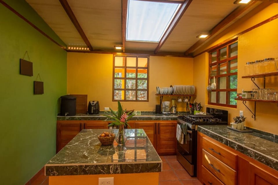 Fully equipped kitchen with wooden cabinets, and natural light in Playa Chiquita, Casa Rakú
