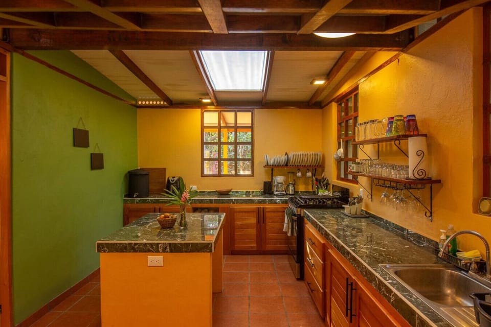 Spacious fully equipped kitchen with island, gas stove, and ample storage in Playa Chiquita, Casa Rakú