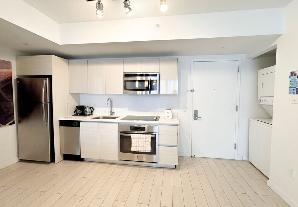 Fully equipped kitchen with stainless steel appliances and a stylish backsplash.