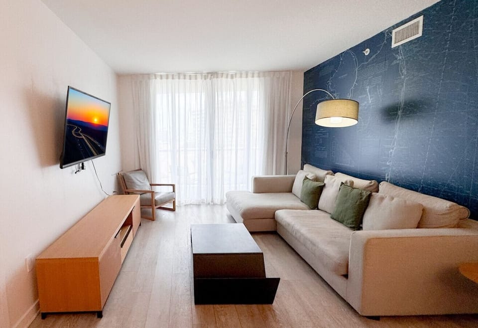 Bright living room with balcony access and city views.