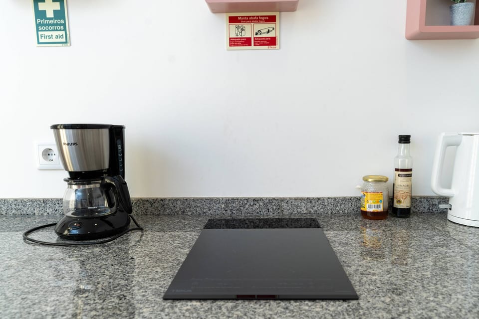 Cozinha moderna e equipada com placa de cozinha e máquina de café. 
