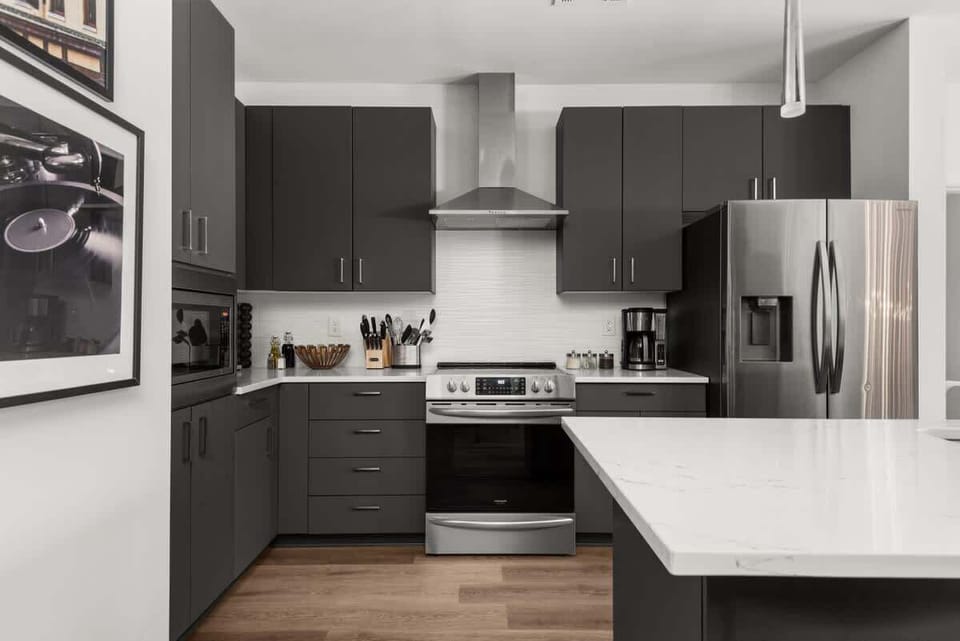 Sleek Contemporary Kitchen: Dark cabinets, stainless appliances, and a marble island create a stylish and functional space.