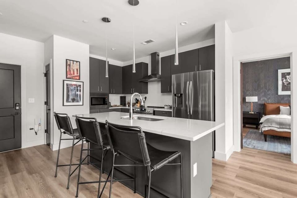 Enjoy cooking in this modern kitchen with its sleek cabinetry, stainless steel appliances, and large island with bar seating.